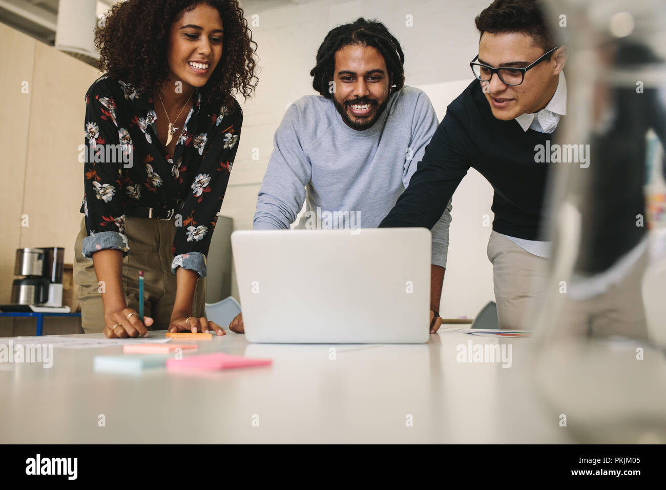Les gens d'affaires créatifs travaillant sur un ordinateur portable et discuter des idées à l'office. Le partage des idées d'entreprise et d'affaires avec des collègues de plans sur bureau Banque D'Images