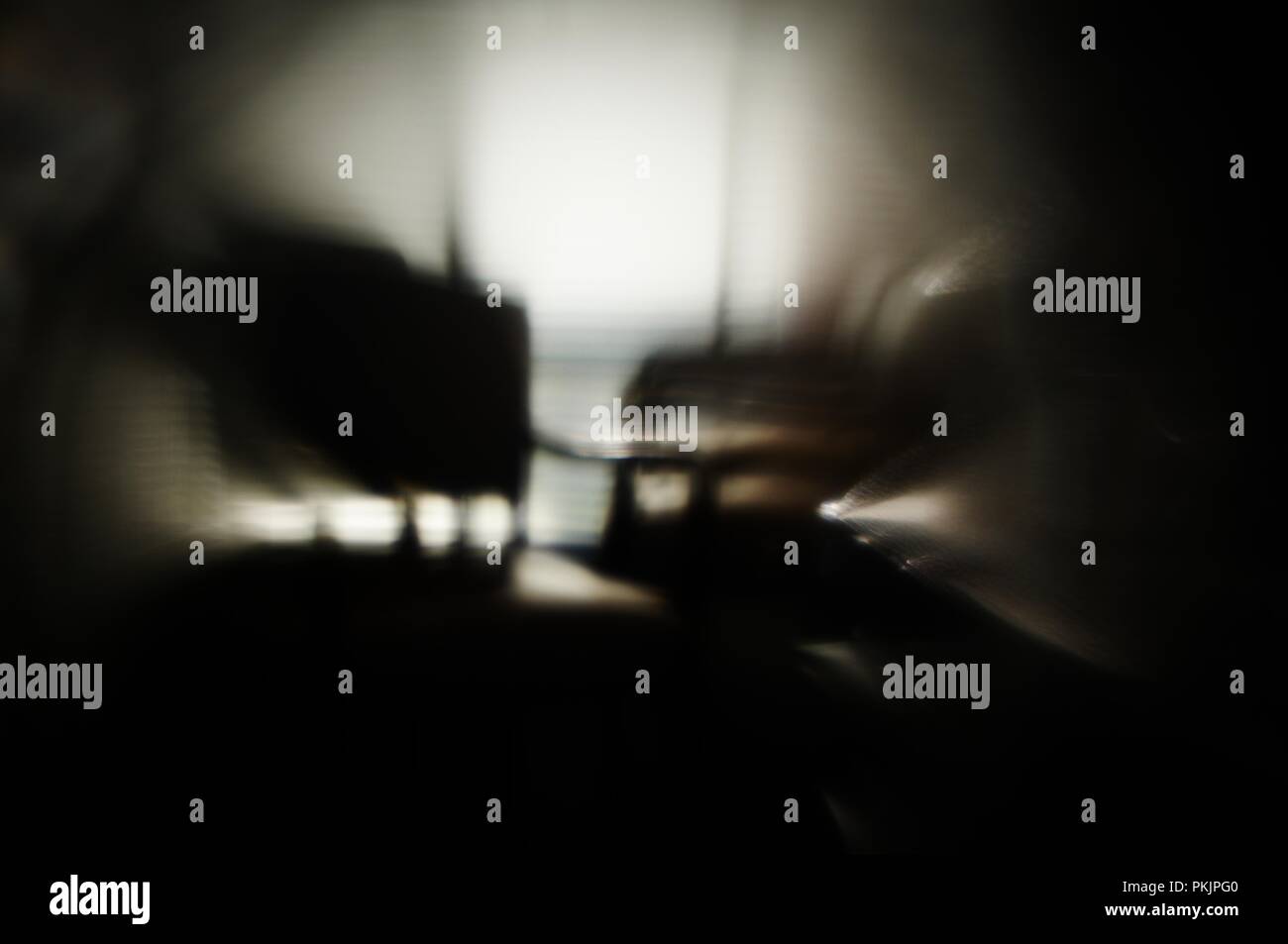 Abrégé d'une chaise ancienne avec jalousie ombres sur il tourné à travers un verre. Banque D'Images