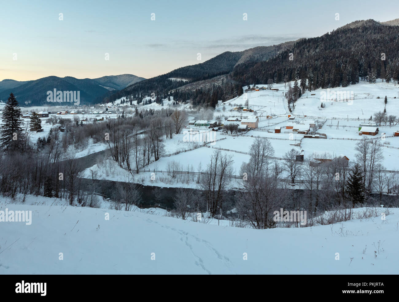 L'aube au crépuscule du matin village de montagne des Carpates hiver Zelene en noir Cheremosh river valley entre Alp. Voir de la neige sur le chemin rural hill Banque D'Images