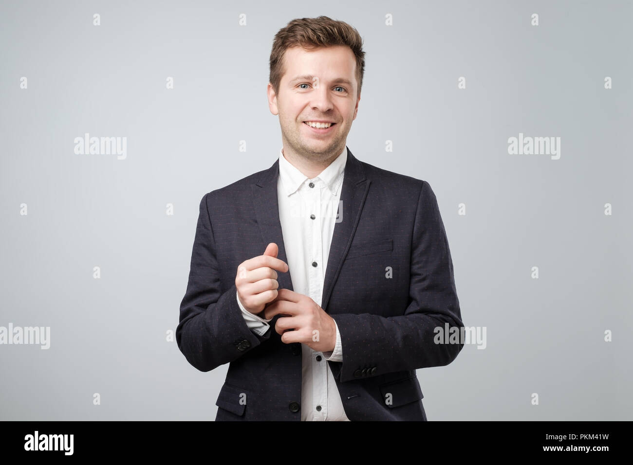 Beau jeune homme élégant confiant debout portant un costume de nice Banque D'Images