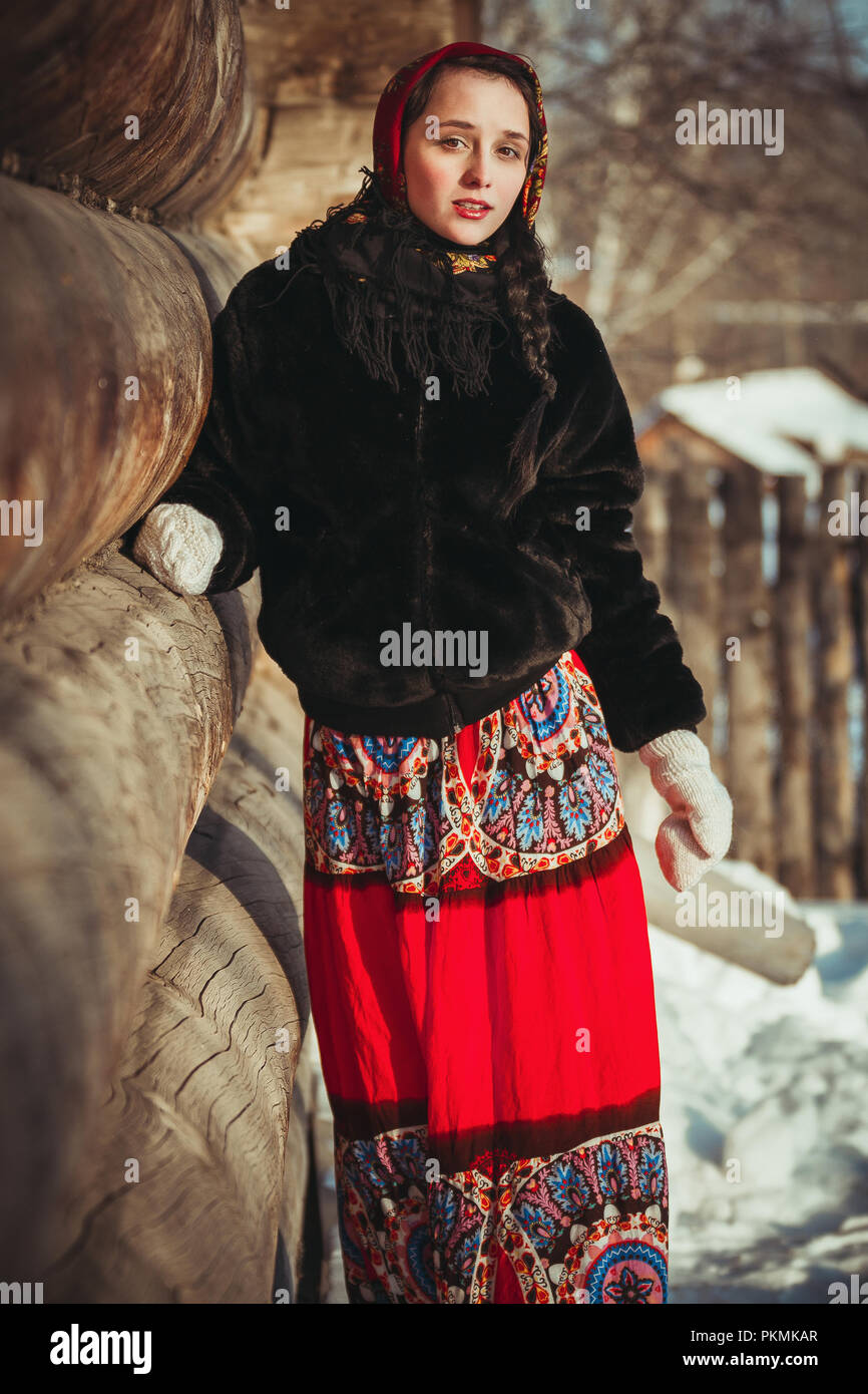 Femme Russe belle dans la robe et le manteau de fourrure en hiver près de  la vieille cabane. Fille avec foulard sur sa tête près d'un log home Photo  Stock - Alamy
