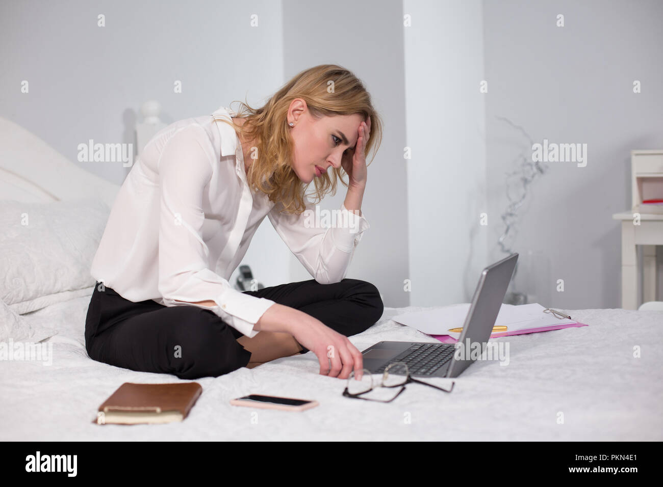 Business Woman sitting on bed et de travail Banque D'Images