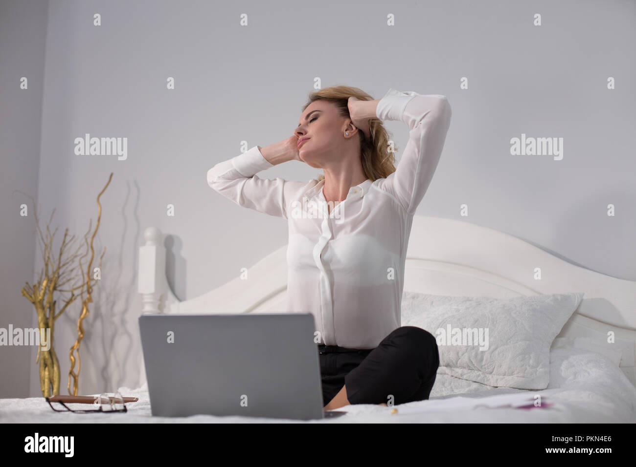 Business Woman sitting on bed et de travail Banque D'Images