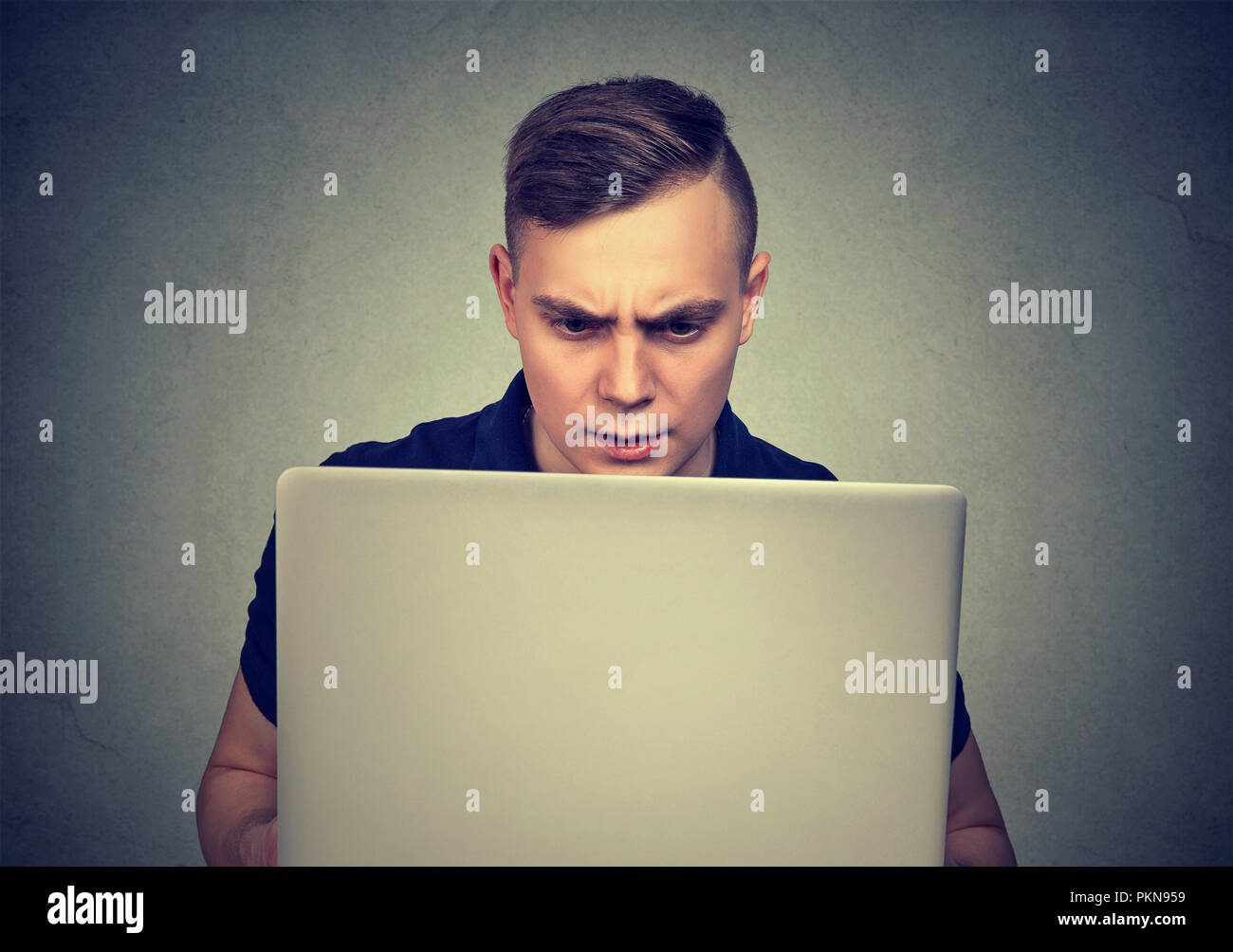 Casual young man using laptop et à la peur des problèmes avec le compte Banque D'Images