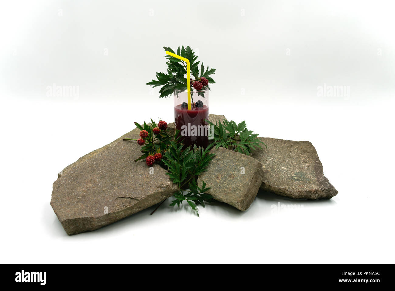 Smoothie aux fruits délicieux avec des mûres et de paille sur des pierres. Studio shot in front of white background. Banque D'Images Smoothie aux fruits délicieux avec des mûres et de paille sur des pierres. Studio shot in front of white background. Banque D'Images