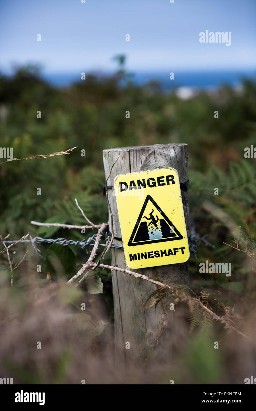 Un signe de détresse jaune informer la population du danger de chute, un puits de mine de la campagne. Banque D'Images