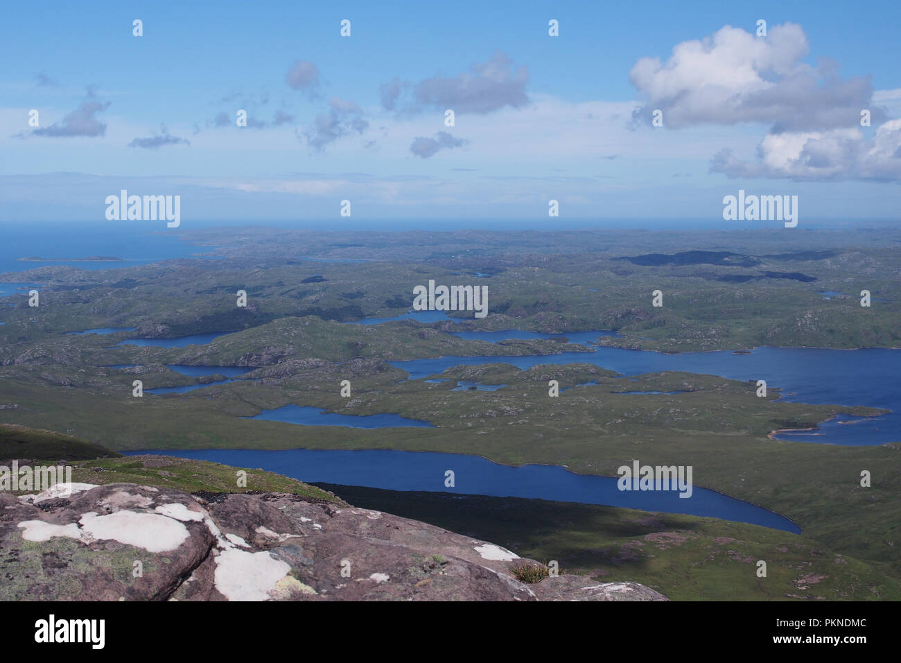 Une vue de Stac Pollaidh nord à l'ouest vers la péninsule de Stoer à travers de nombreux petits lacs à l'horizon sur une journée ensoleillée Banque D'Images