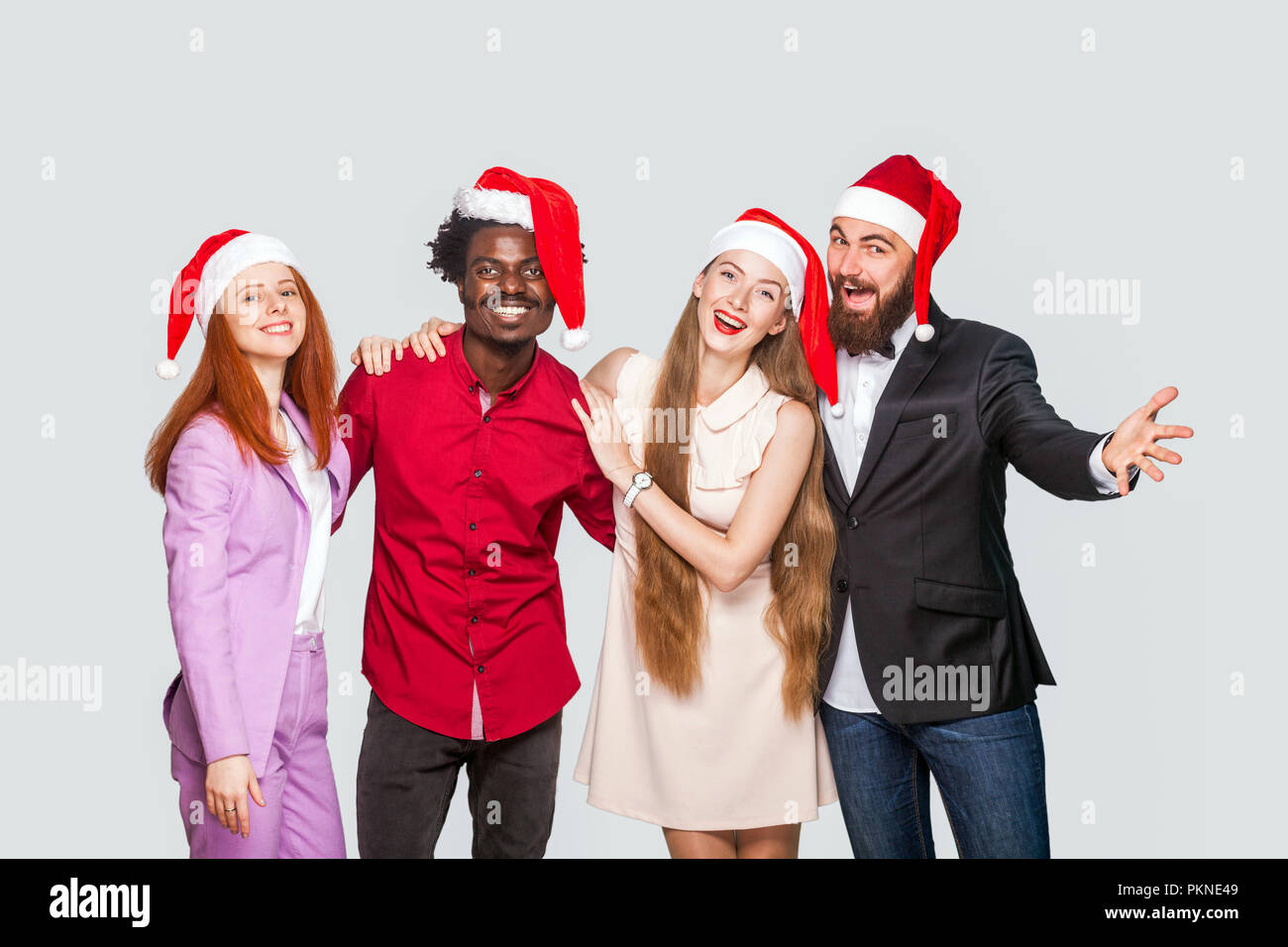 Groupe d'amis dans beautiful happy beau bonnet rouge debout et célébrer la  nouvelle année, à la caméra avec le sourire à pleines dents. Piscine studio  shot, isola Photo Stock - Alamy