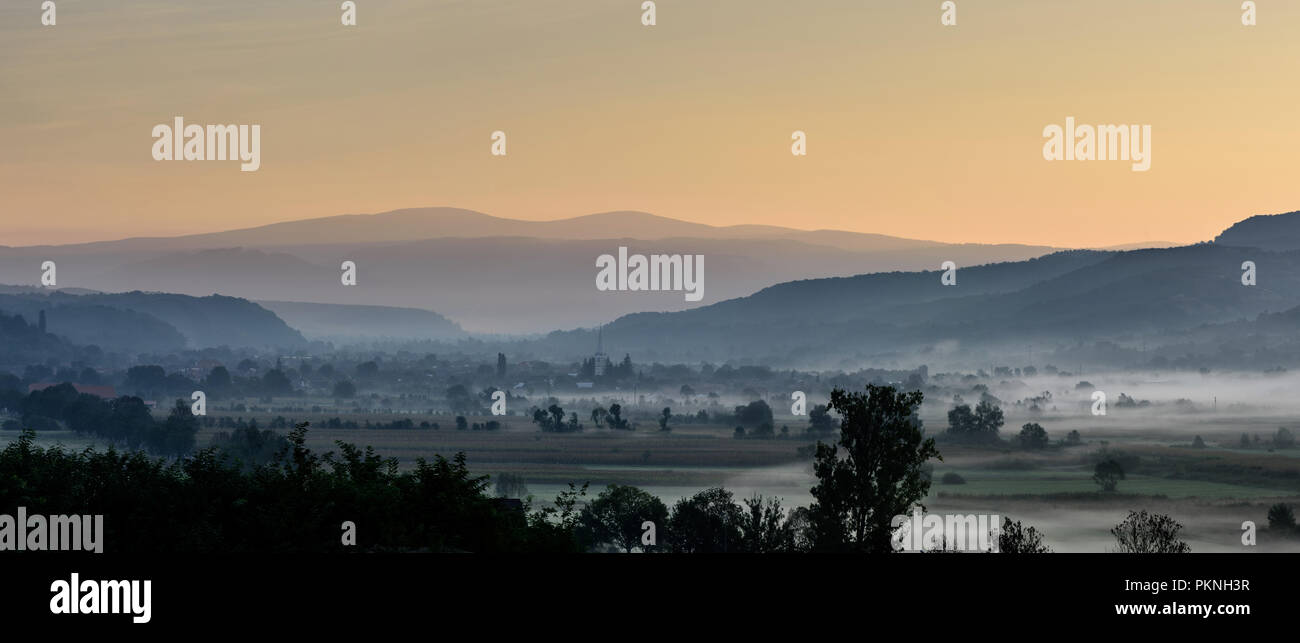 La campagne à couper le souffle des petits matins village transylvain couverts dans le brouillard. Matin d'automne. Banque D'Images