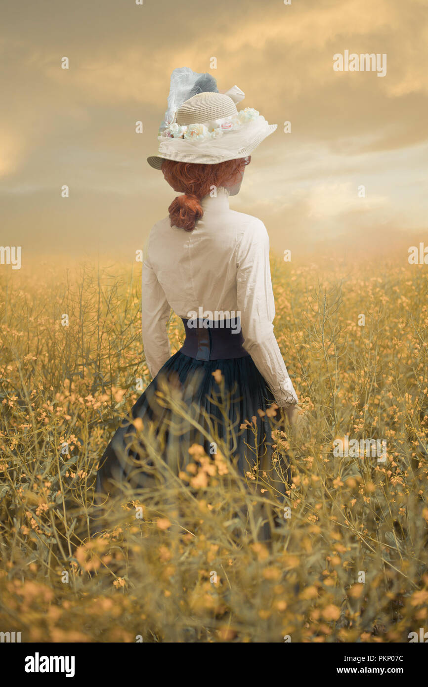 Victorian woman standing in champ de fleur à l'été Banque D'Images