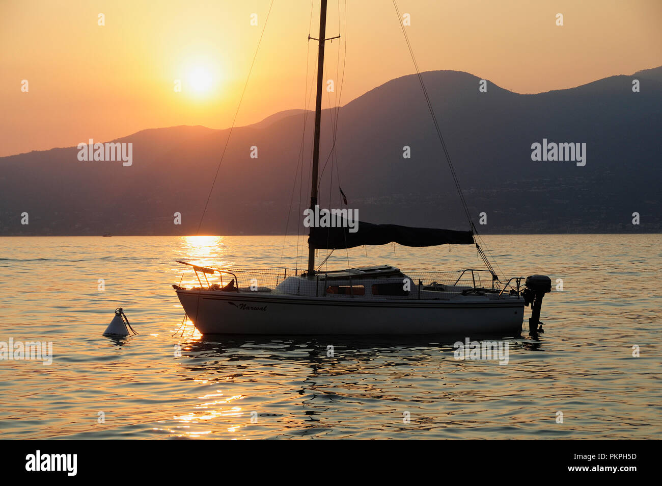 Italie, Vénétie, le lac de Garde, le coucher du soleil sur le lac en bateau. Banque D'Images