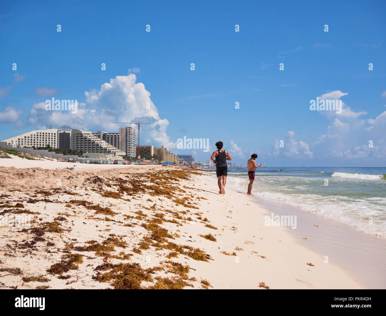 Young man jogging on Tropical Beach Paradise de Playa Delfines, Cancun, Mexique, le 7 septembre 2018 Banque D'Images