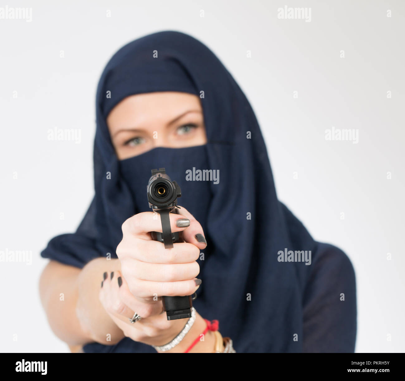 Fille dans un foulard avec une arme à feu Banque D'Images