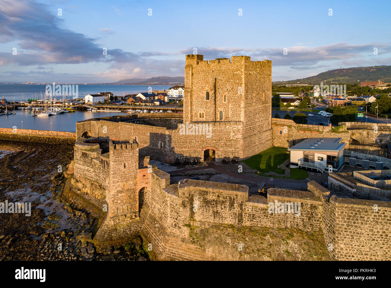 Cité médiévale du château normand à Carrickfergus près de Belfast dans le lever du soleil la lumière. Vue aérienne avec marina, yachts, parking, vue sur la ville et loin de Belfast. Banque D'Images