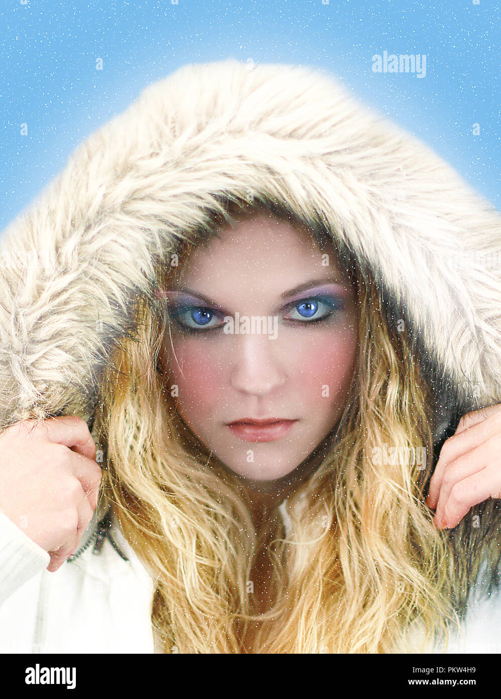 Belle image de la reine de glace woman wearing white parka avec capuche et yeux bleus perçants. Banque D'Images