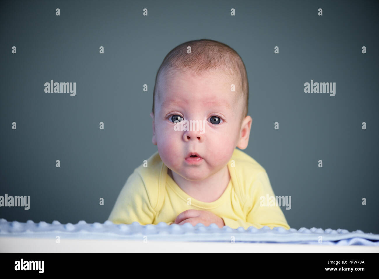 Bébé nouveau-né garçon sur tapis bleu closeup Banque D'Images