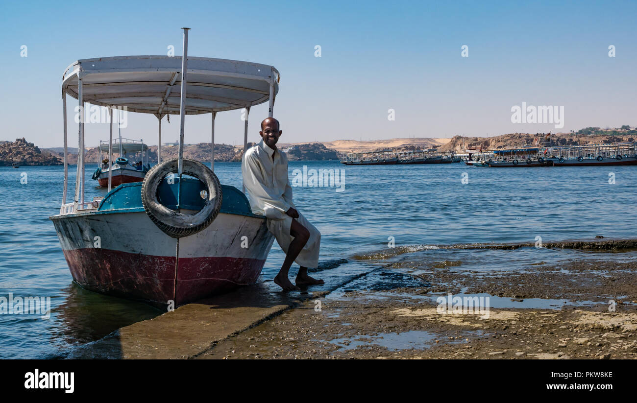 L'homme égyptienne locale traditionnelle en robe blanche avec voile sur lac Nasser en attente de transport de touristes pour le Temple de Philae, Assouan, Egypte, Afrique du Sud Banque D'Images