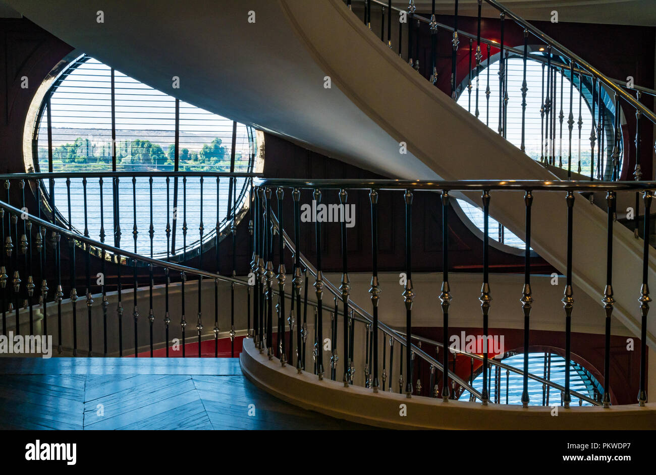 Intérieur du bateau de croisière touristique Mme Mayfair avec grand escalier circulaire et vue sur rivière à travers hublots, Nil, Assouan, Egypte, Afrique du Sud Banque D'Images