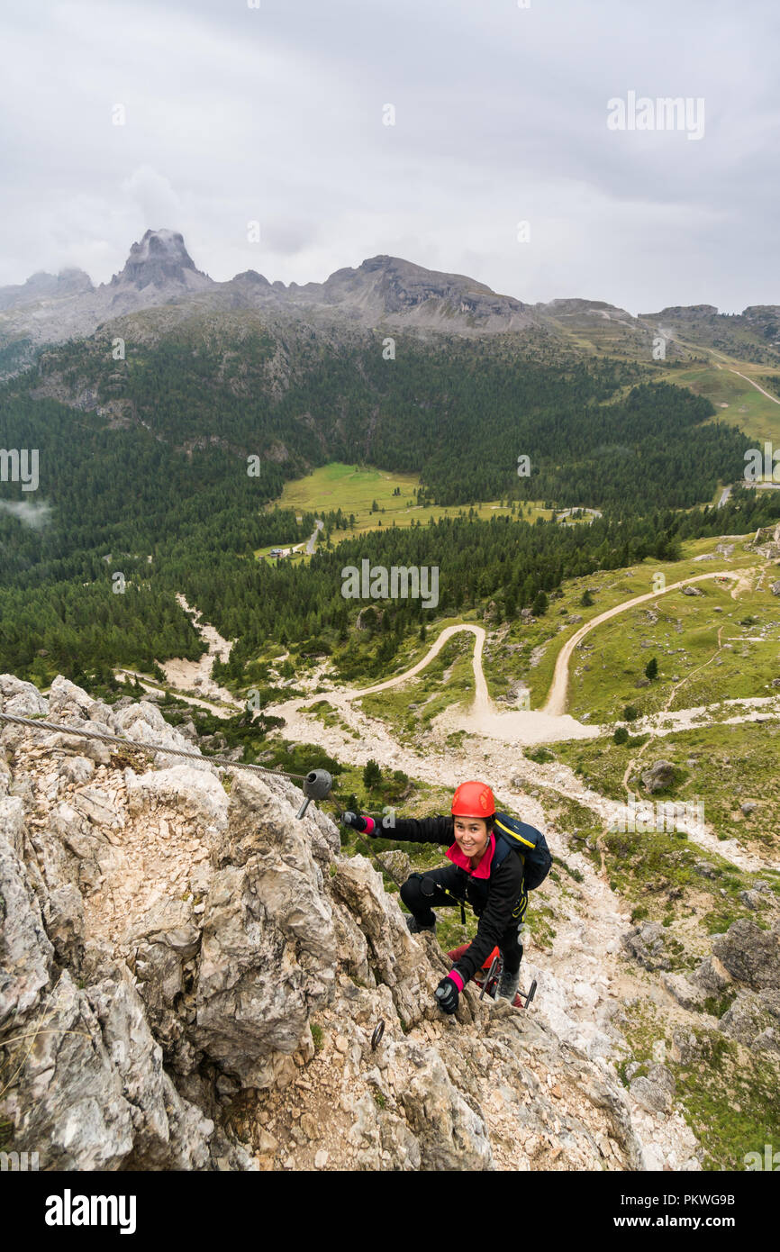 Les jeunes femmes attrayantes d'alpiniste sur une pente raide et exposé Via Ferrata en Alta Badia dans le Tyrol du Sud dans les Dolomites italiennes Banque D'Images