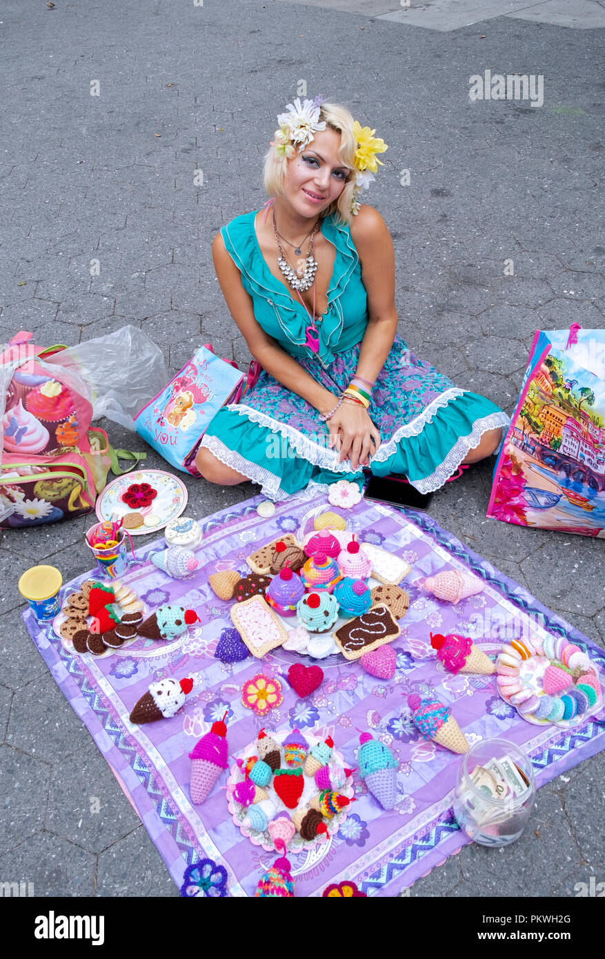 Une belle jeune femme qui vend des répliques de tricot main articles alimentaires et des desserts. Dans la région de Union Square Park à Manhattan, New York City. Banque D'Images