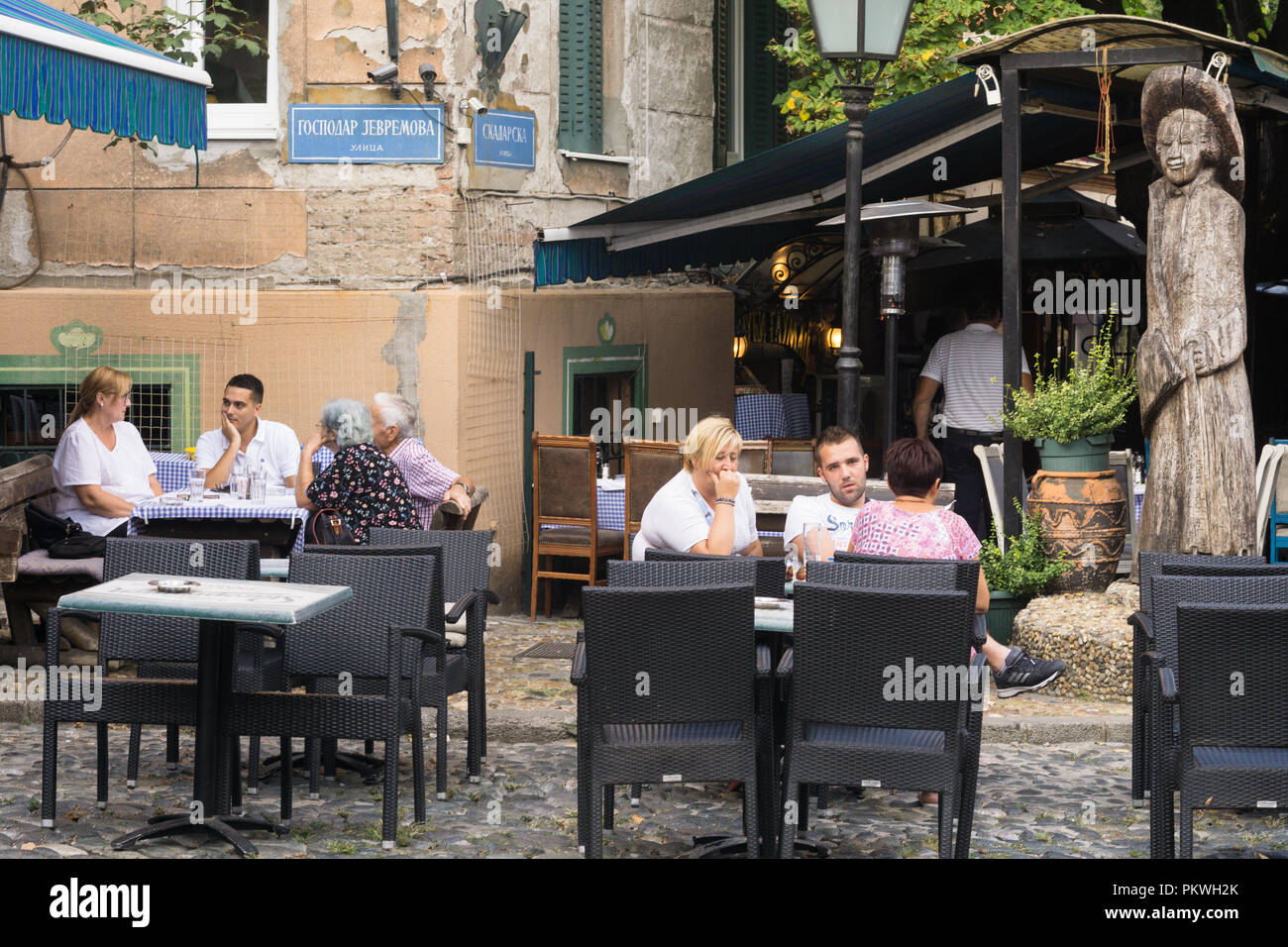Les gens bavarder à l'Acteur Voyage restaurant à Skadarlija, Belgrade. La Serbie. L'Acteur Voyage statue est une marque commerciale du restaurant. Banque D'Images