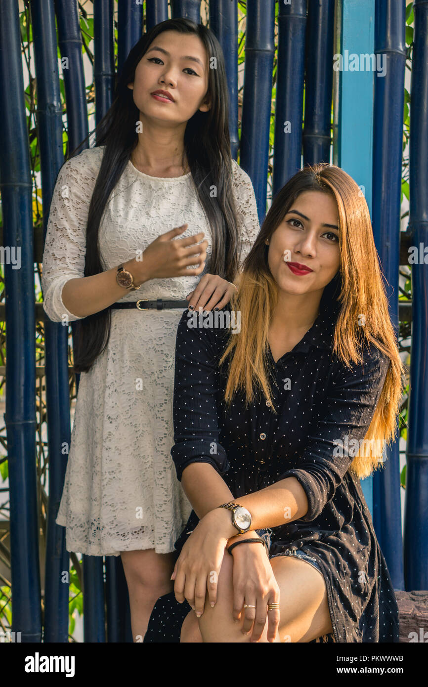 Deux jeune fille posant pour l'appareil photo sur un fond bleu. Banque D'Images