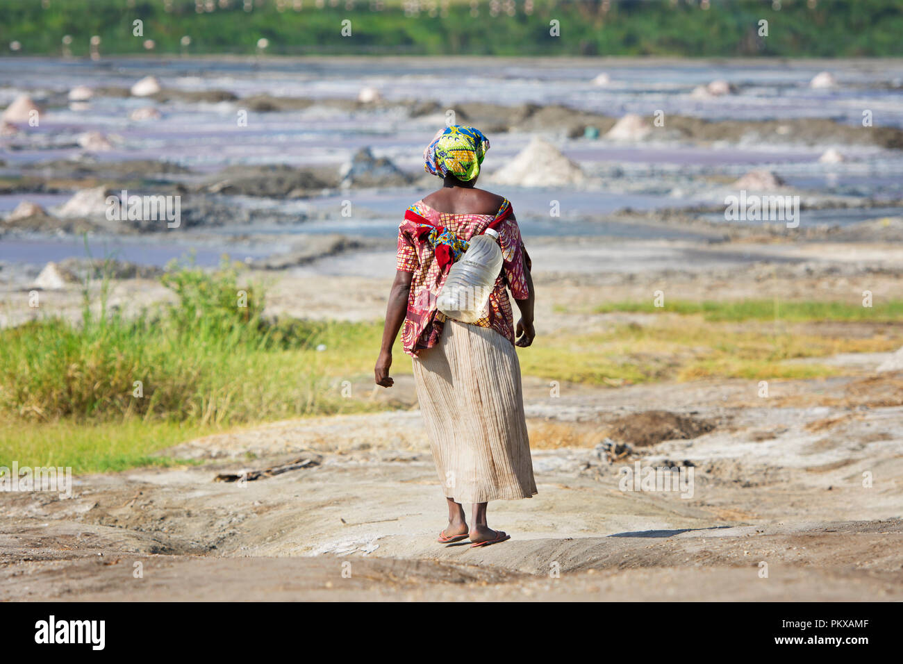 Femme portant de l'eau en bouteille plastique, en Ouganda, en Afrique de l'Est Banque D'Images