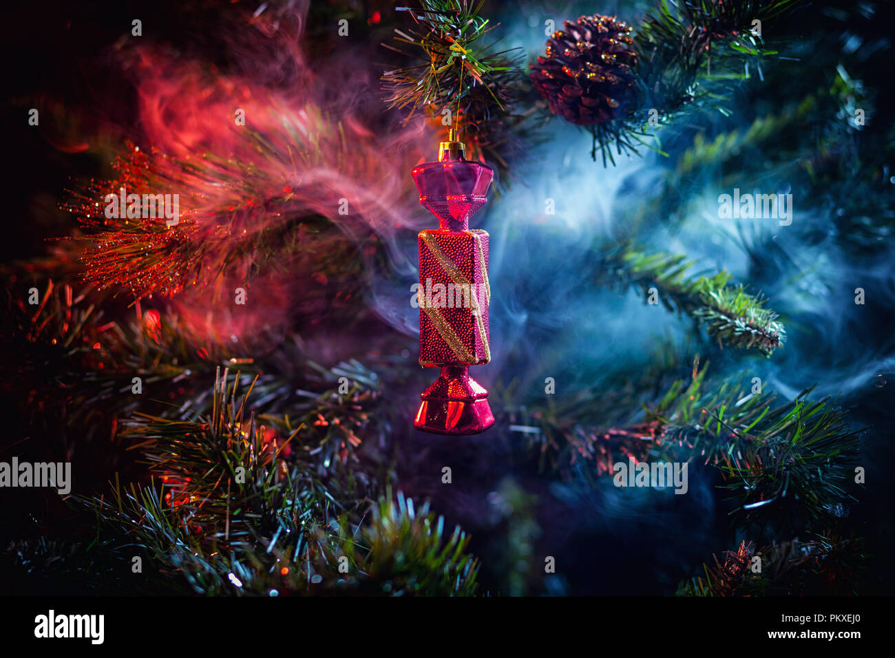 La décoration des boules de Noël rouge brillant avec des bonbons dans la chambre de fumée de couleur violet-rouge, sur un fond d'arbres de Noël. Concept d'une voiture de Noël moderne Banque D'Images