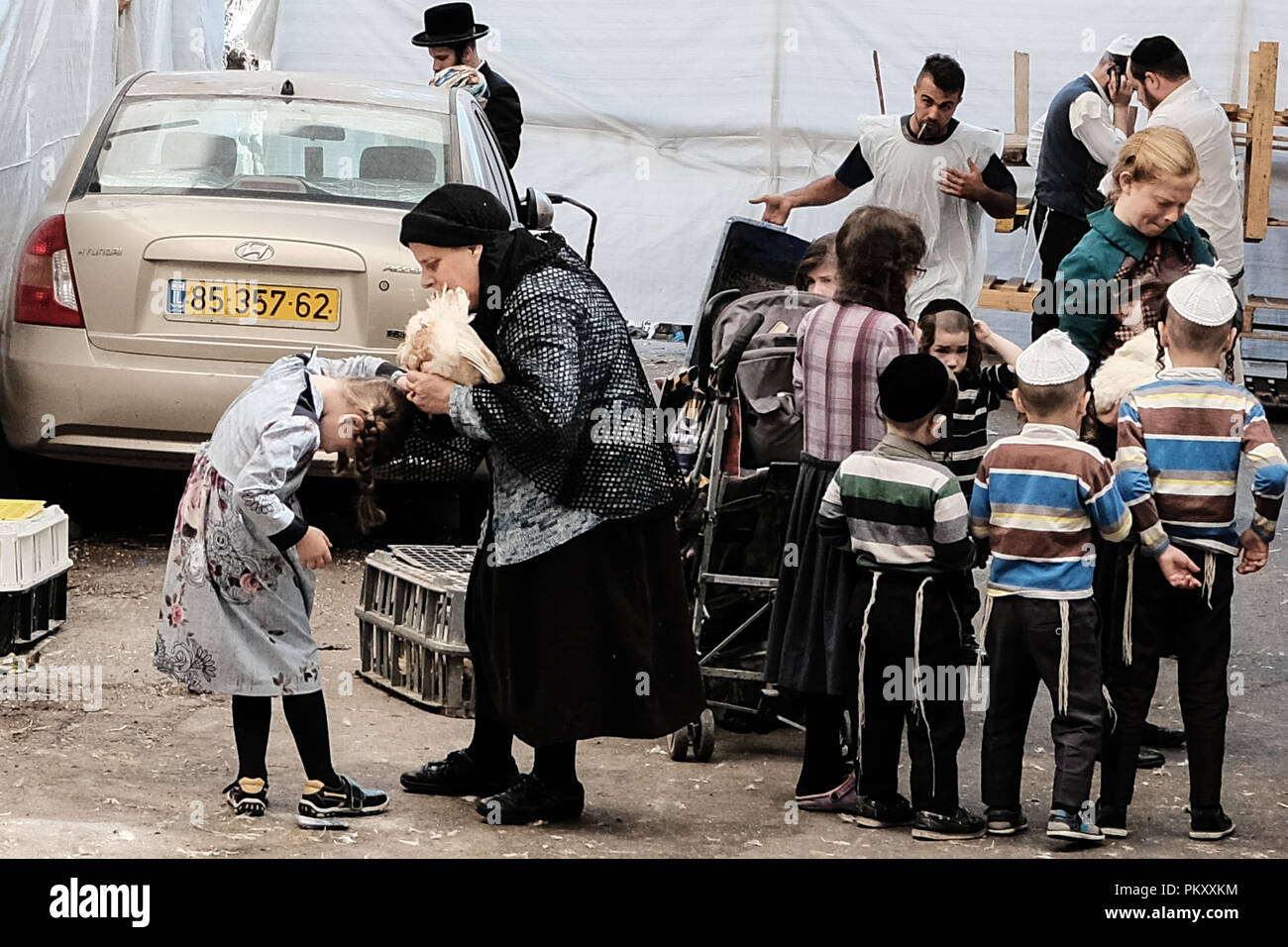 Jérusalem, Israël. 16 Septembre, 2018. Une mère effectue le rituel juif des Kapparot sur ses enfants à la veille de Yom Kippour, le Jour des Expiations, dans le quartier ultra-orthodoxe de Mea Shearim, balançant un poulet vivant au-dessus de leurs têtes pour l'expiation des péchés devant Dieu et la purification. Credit : Alon Nir/Alamy Live News Banque D'Images
