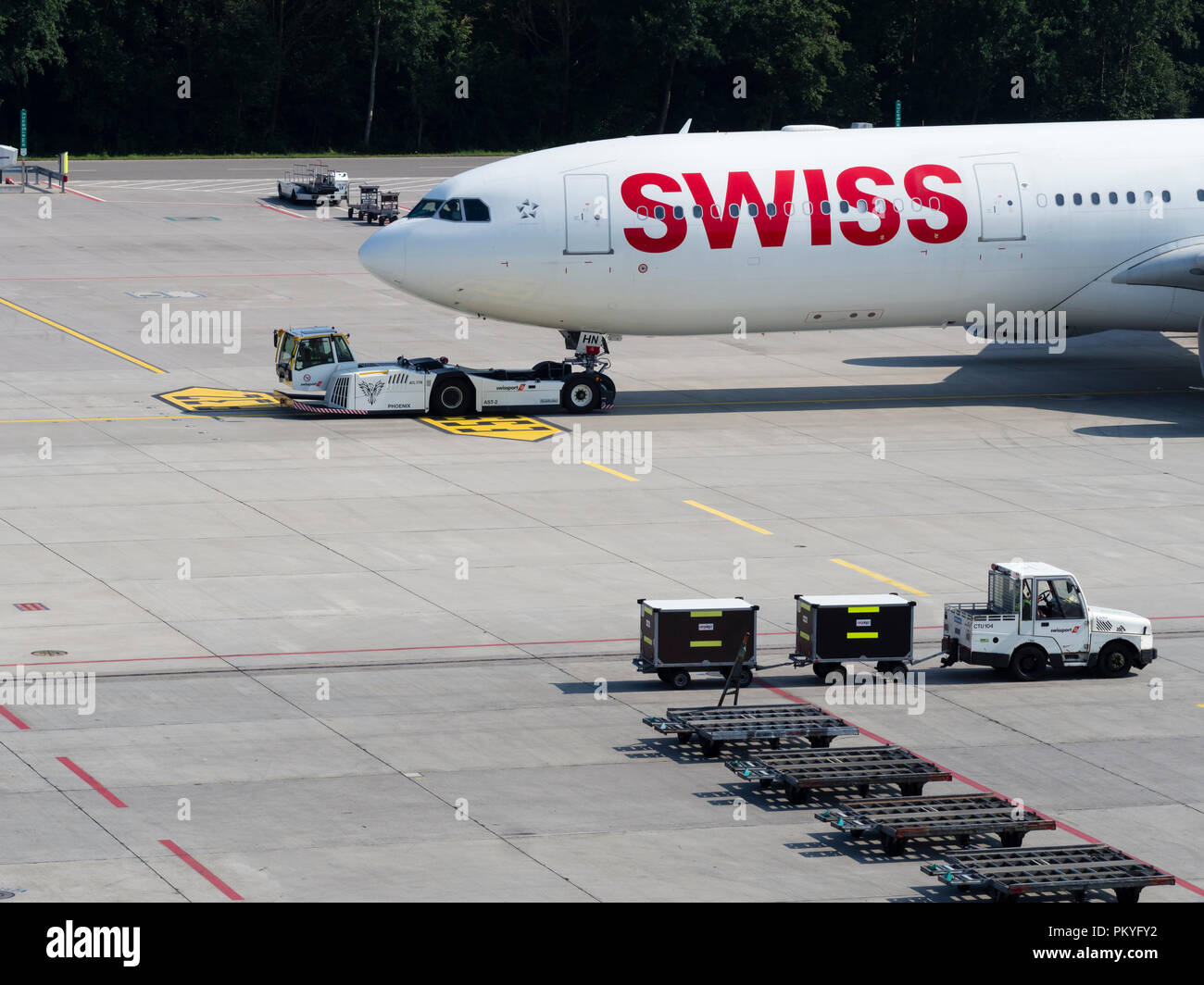 Un avion remorqueur tire un Airbus A340 de Swiss International Air Lines à l'écart de la porte à l'aéroport international de Zurich. Banque D'Images