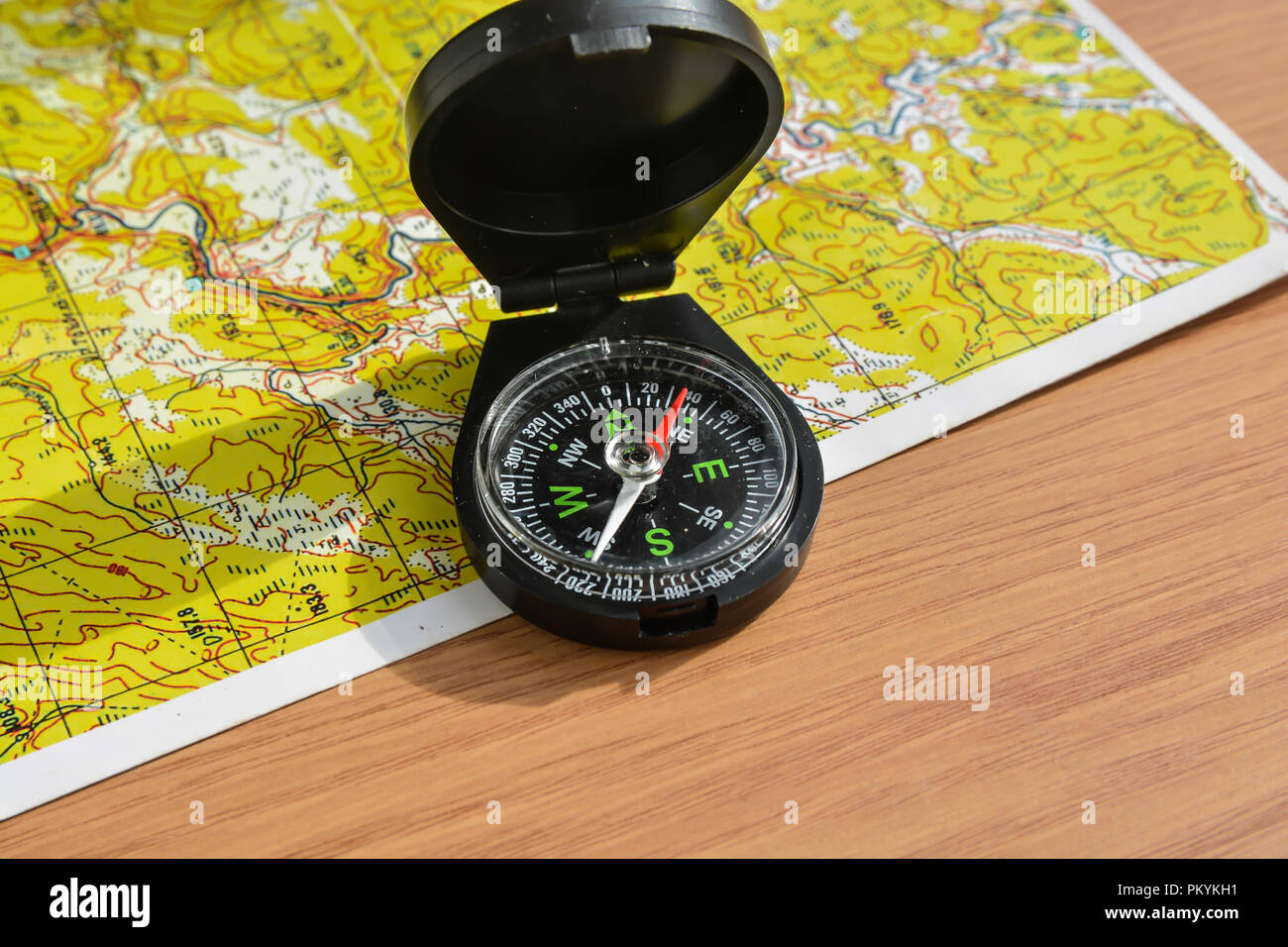 Boussole et carte. Le compas magnétique est situé sur une carte topographique. Banque D'Images