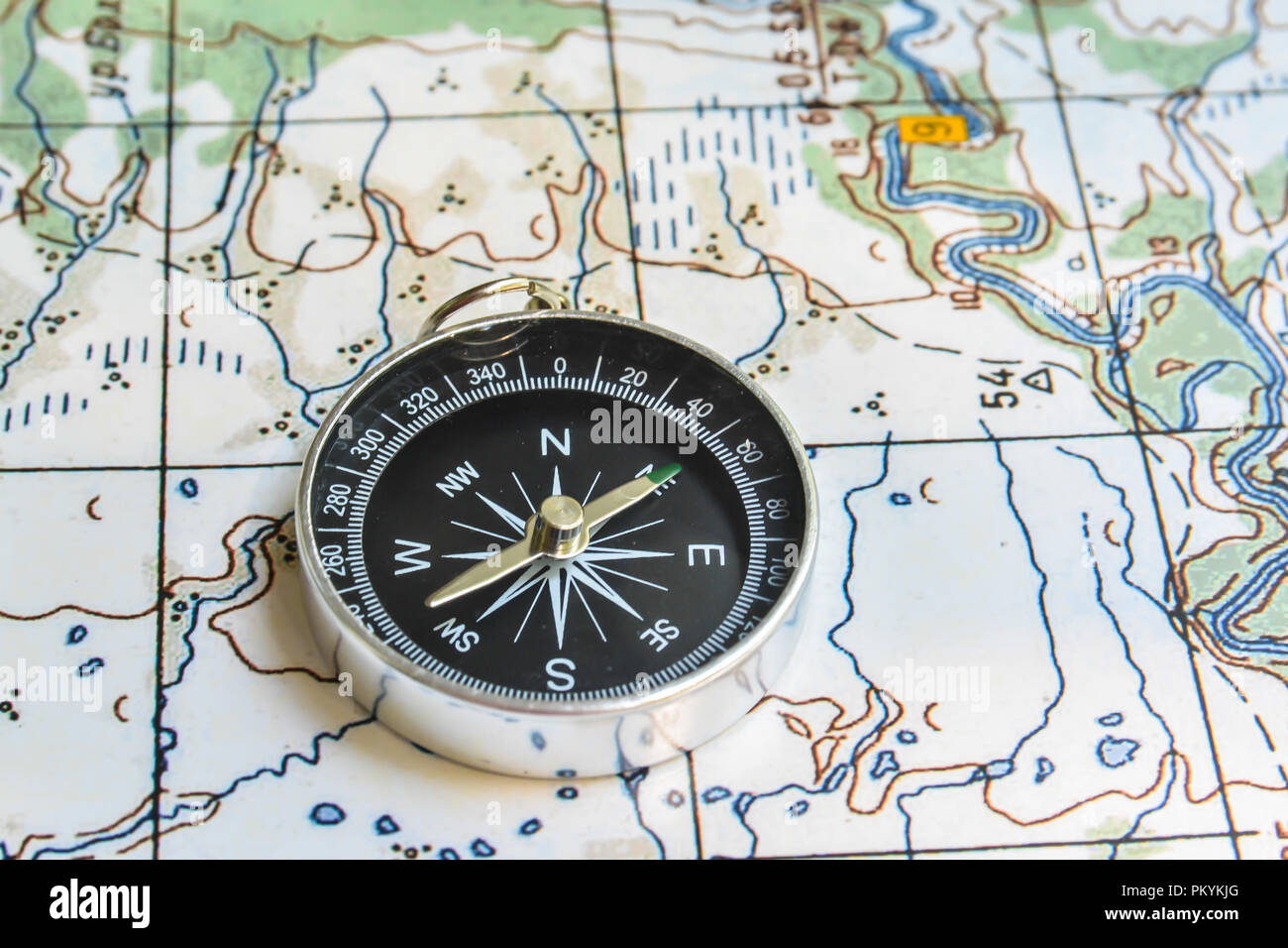 Boussole et carte. Le compas magnétique est situé sur une carte topographique. Banque D'Images