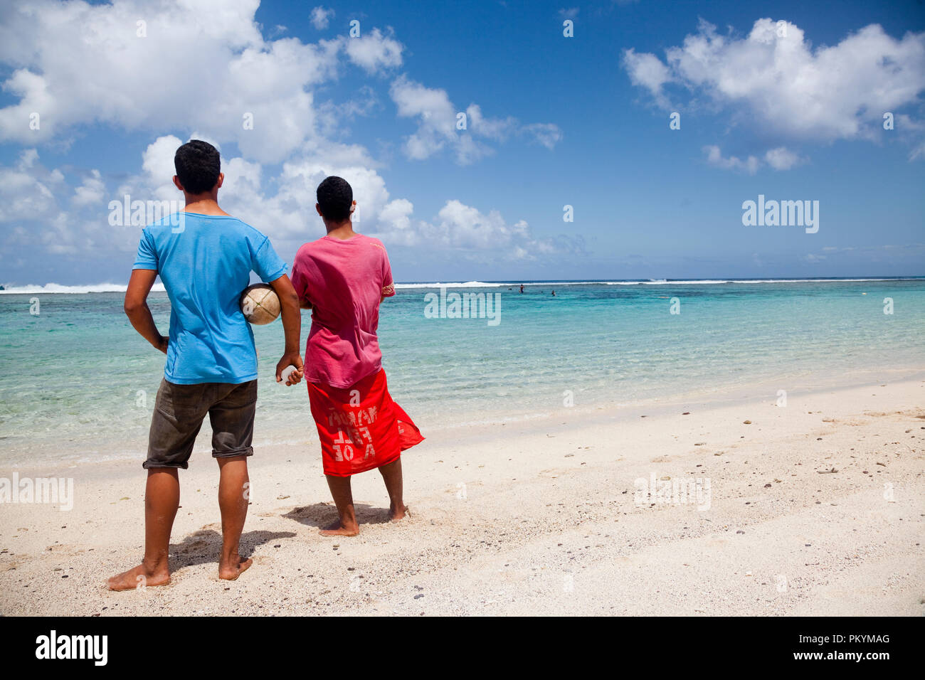 Les sections locales de prendre une pause de beach rugby pour regarder les gens de la pêche dans la lagune près de Lepa Beach, île d'Upolu, Samoa. Banque D'Images