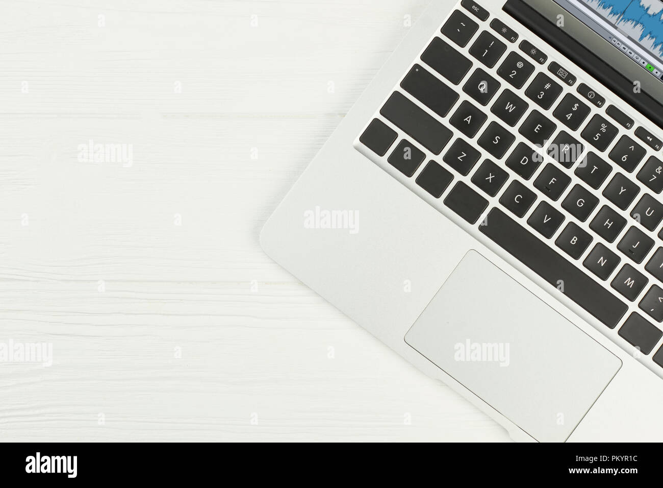 Ordinateur portable sur fond blanc. Ordinateur portable pc d'argent sur la surface en bois blanc avec copie espace, l'image recadrée. Banque D'Images