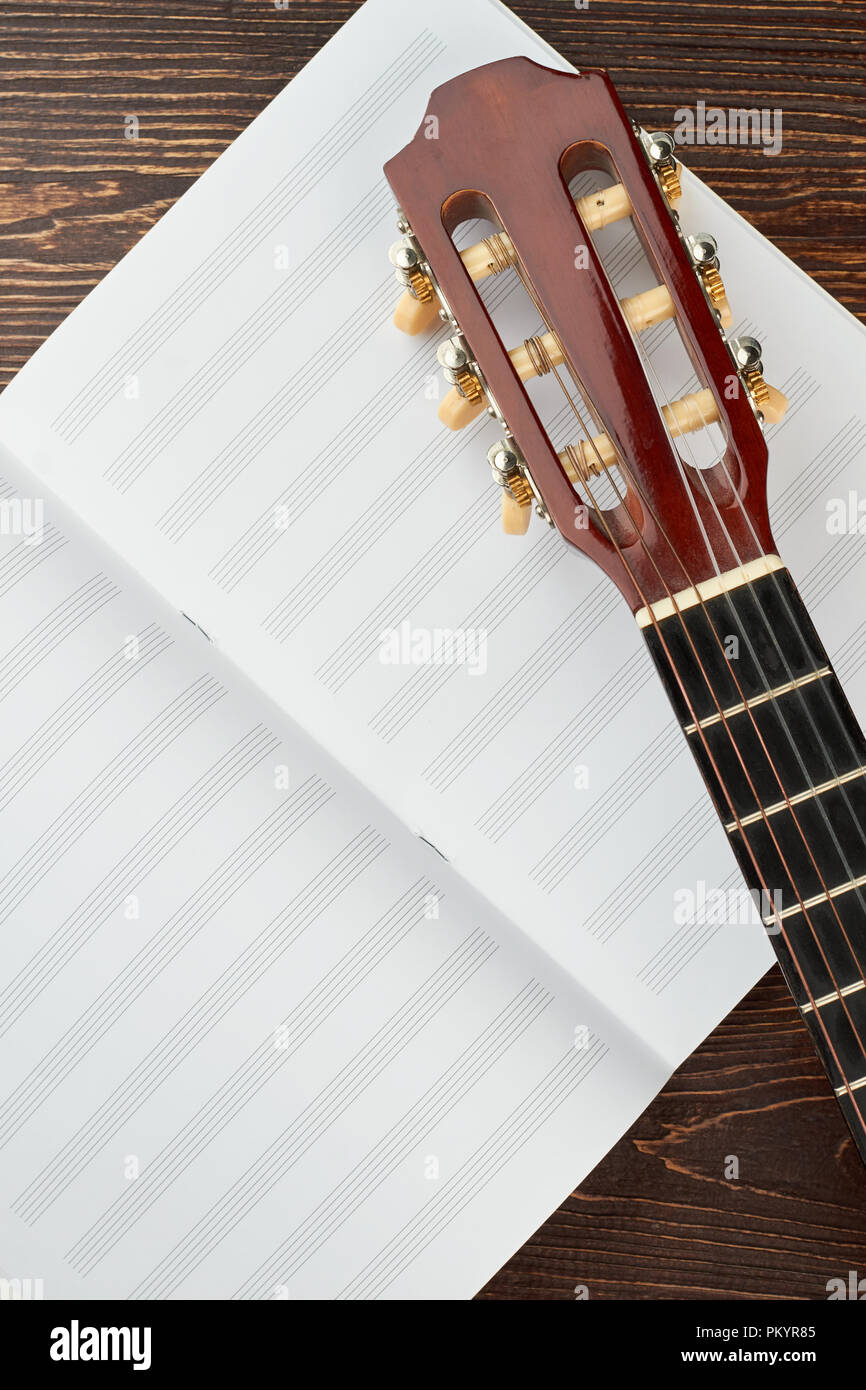 Carnet pour les notes de musique et de la guitare. Vue de dessus sur blank notebook pour les notes de musique et de guitare tête sur fond de bois. Banque D'Images