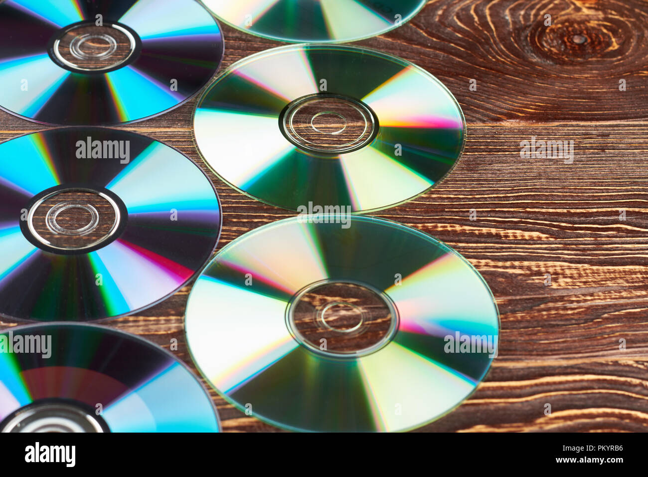 Groupe de disques compact, coloré et copier l'espace. De nombreux disques cd et dvd brillant sur fond de bois de près. Médias numériques des dvd. Banque D'Images