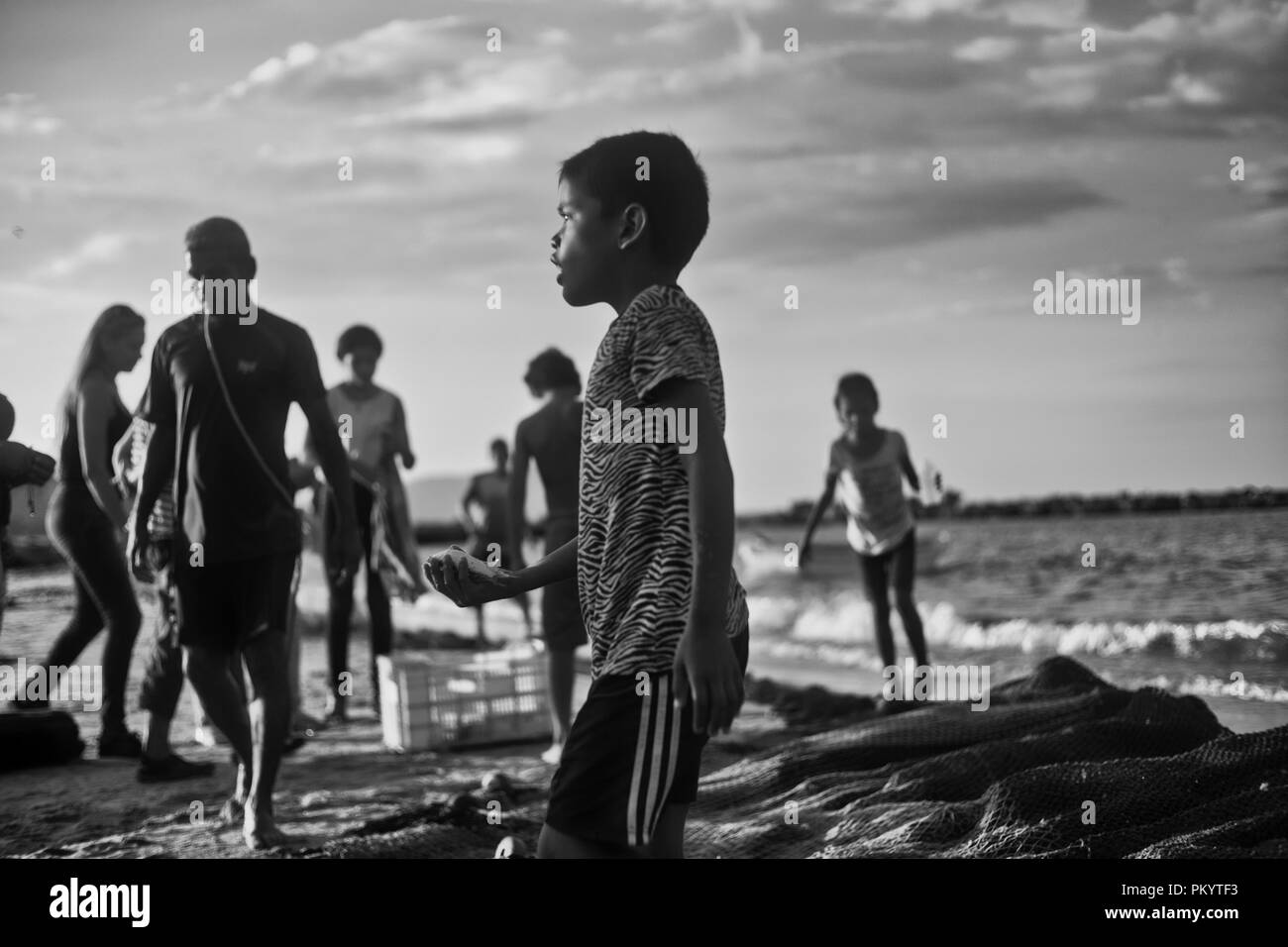 Enfant tient un petit poisson dans sa main. Style rétro la photographie noir et blanc Banque D'Images