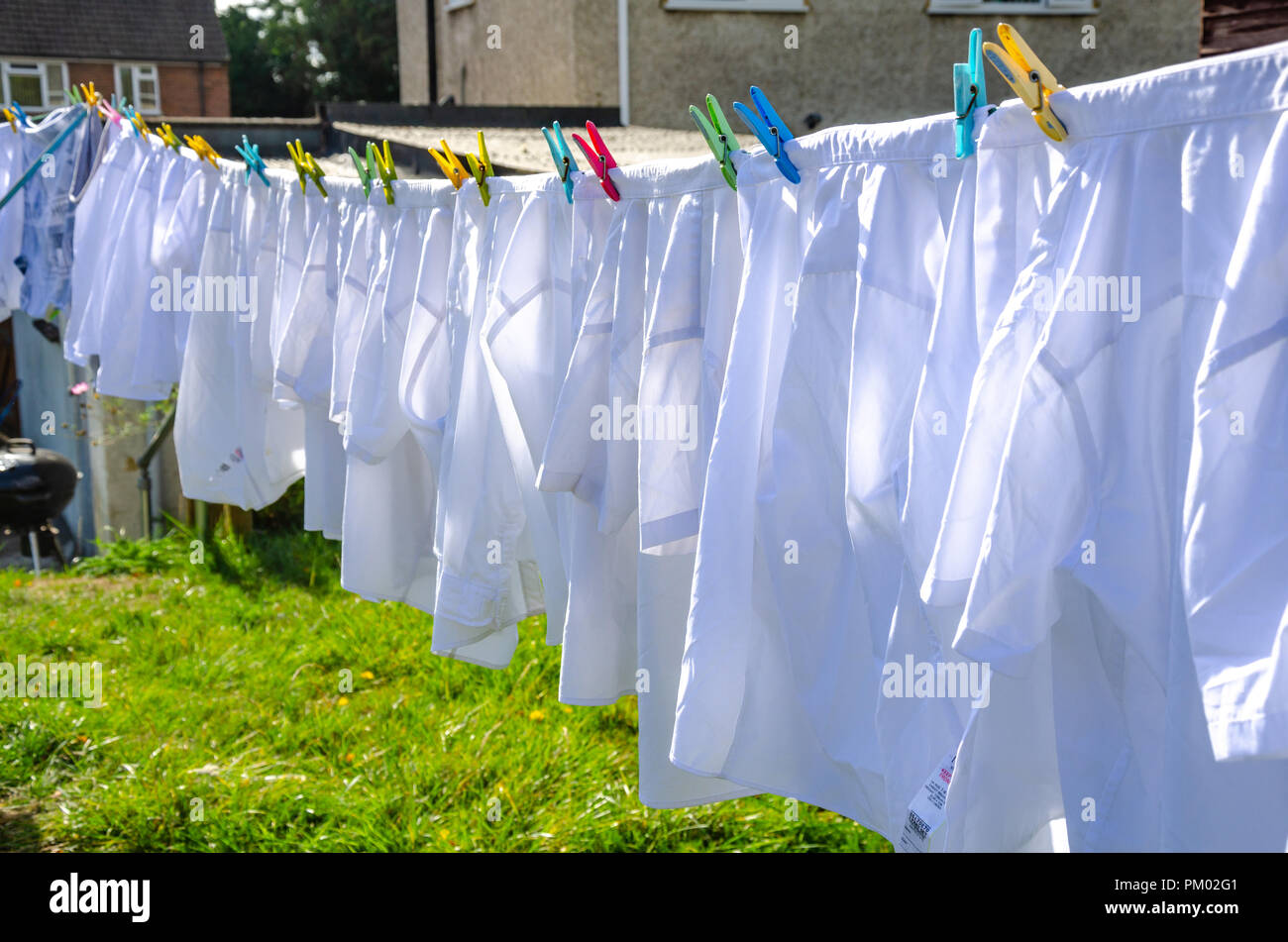 Chemise blanche en train de sécher dehors sur une ligne de lavage dans un  quartier résidentiel jardin arrière Photo Stock - Alamy