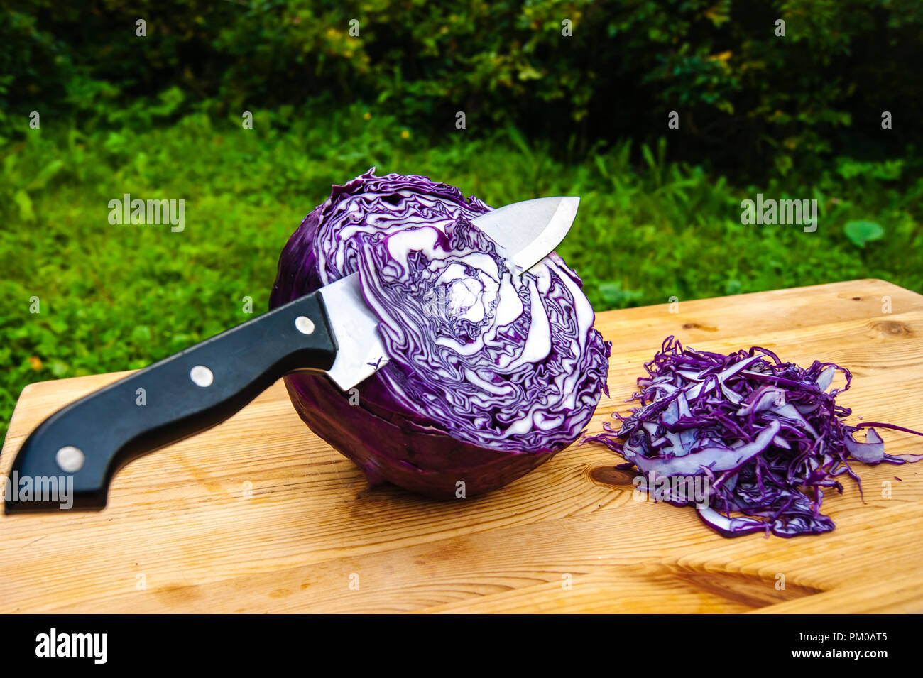 Chou rouge au couteau sur une planche à découper. Toujours à l'extérieur. vie culinaire Banque D'Images