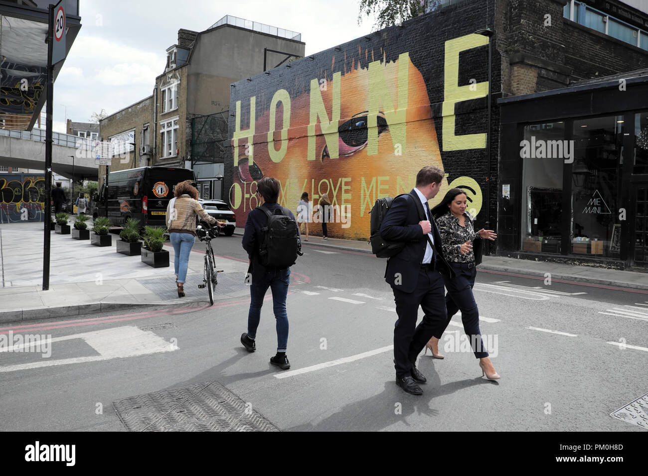 Les gens qui marchent dans la rue en dehors de l'hôtel citoyen m'honne wall mural street art peinture sur Holywell Lane dans Shoreditch East London UK KATHY DEWITT Banque D'Images
