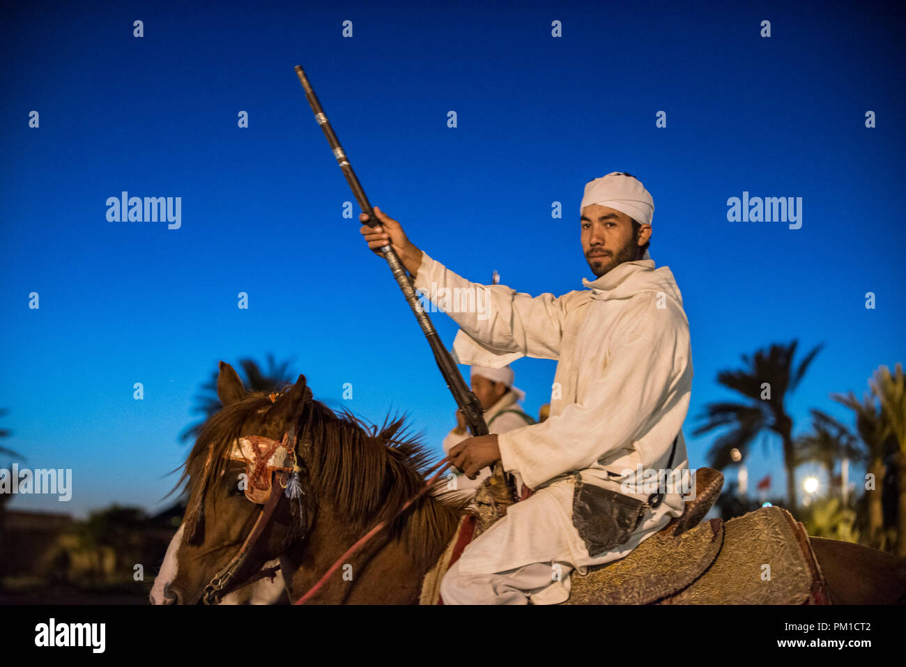 26-02-15, Marrakech, Maroc. L'homme en costume traditionnel à cheval avec arme sur l'attraction touristique de Fantasia / Chez Ali. Photo © Simon Grosset Banque D'Images