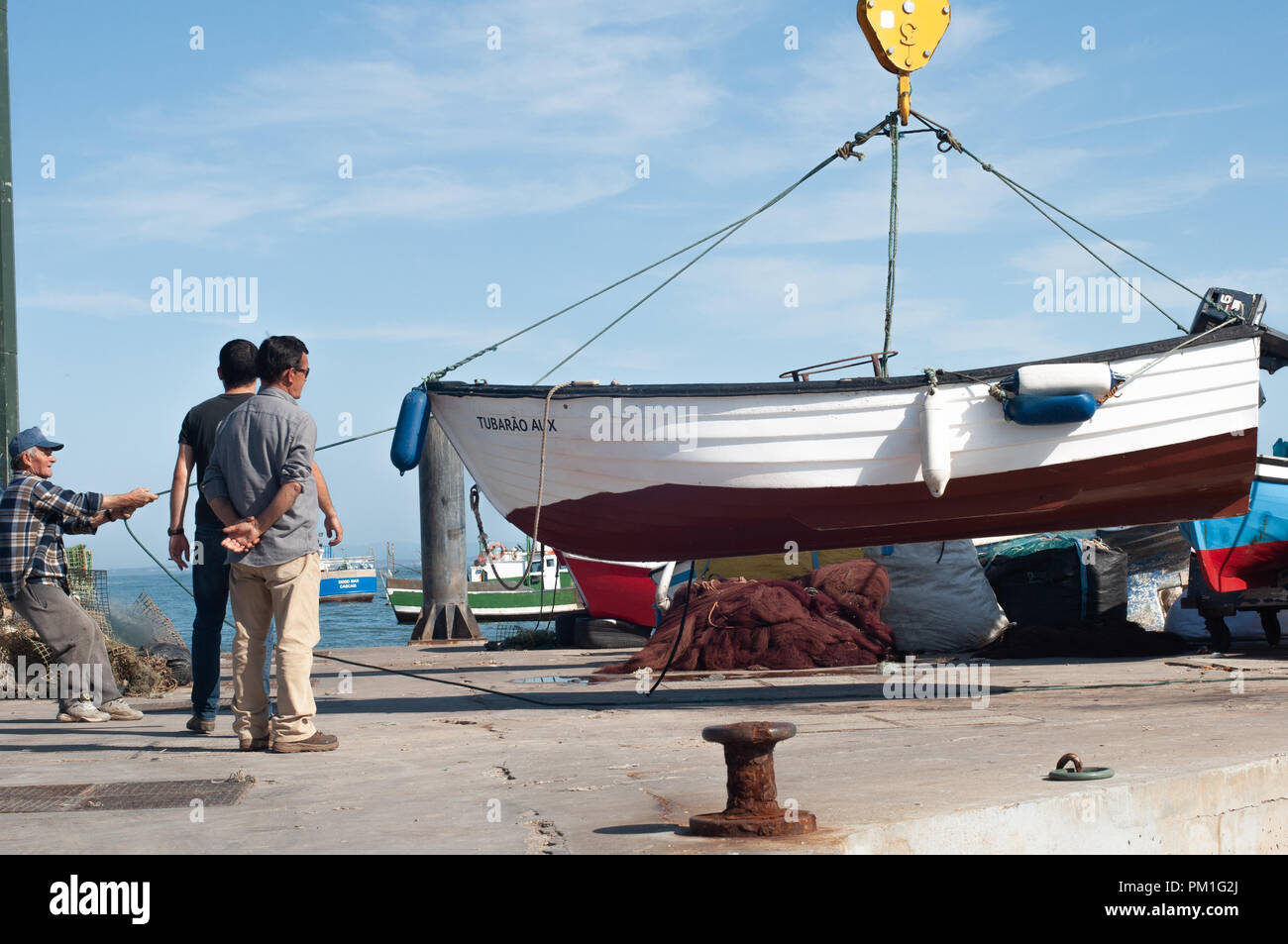 Levage hommes Bateau de pêche pour mettre dans l'eau à l'aide de bateau grue Banque D'Images