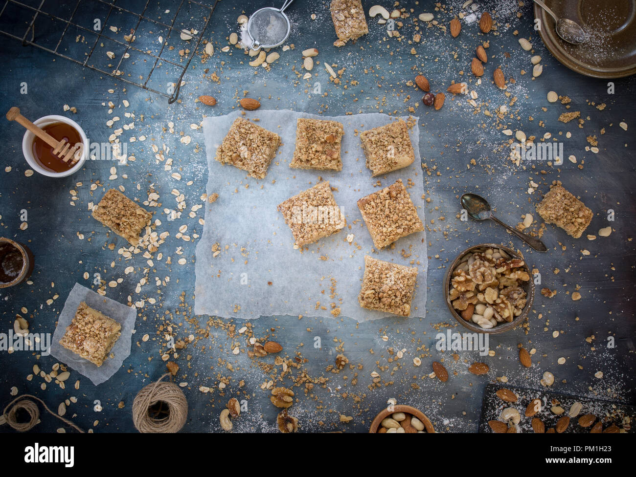 Des tranches au caramel du papier sulfurisé, avec un fond bleu texturé y compris les noix, graines et céréales une flatlay frais généraux de droit, partie d'une série Banque D'Images