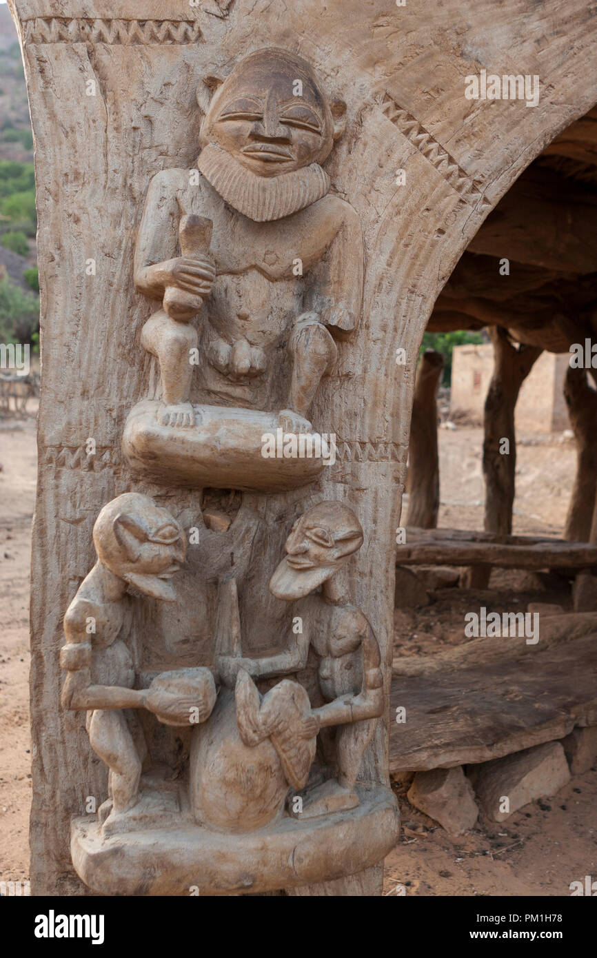 Sculpture en bois Dogon sur un "toguna" (ou cabane de palabre) pilier. La sculpture représente 3 Hommes Banque D'Images