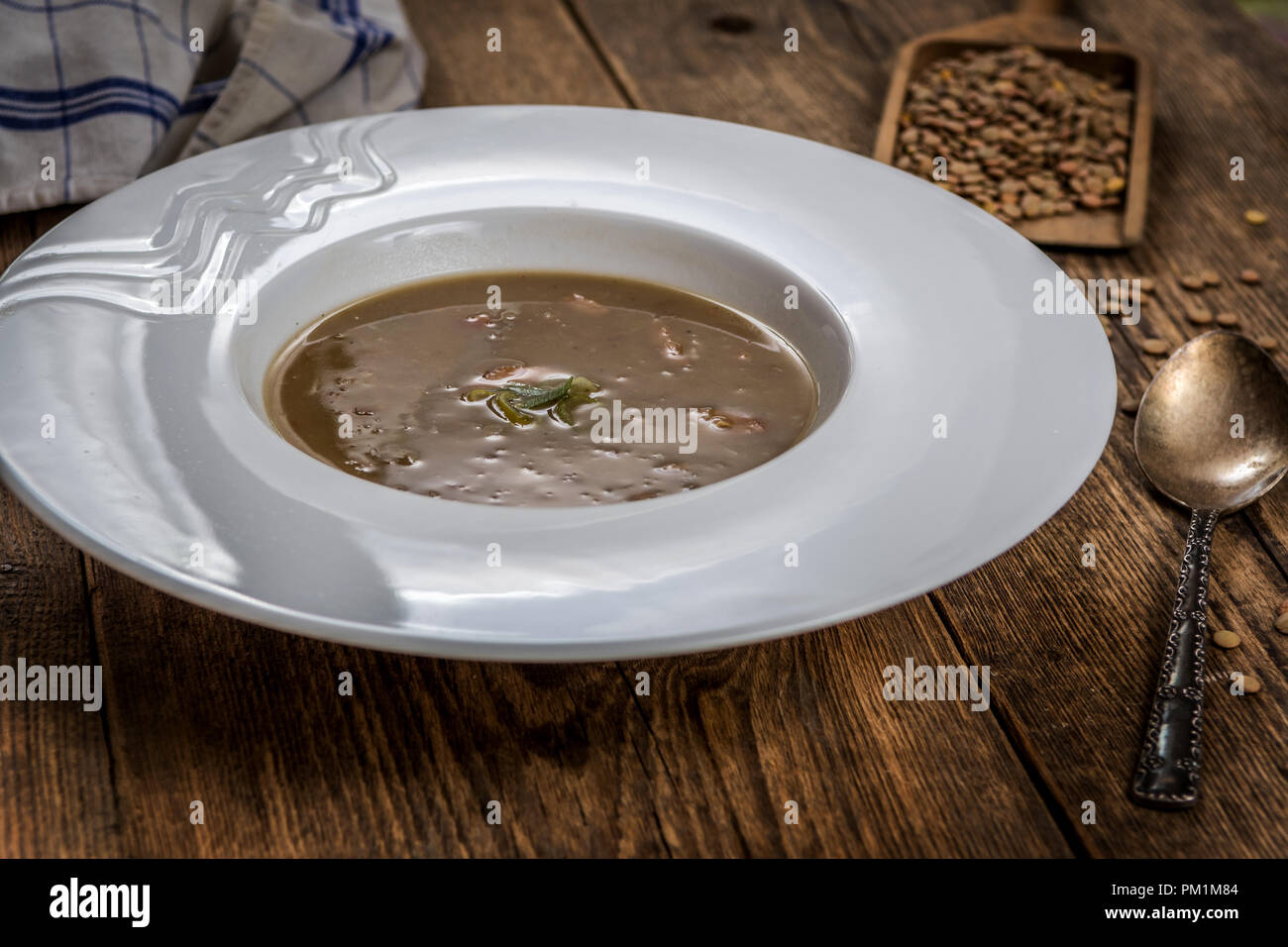 Lentilles brunes avec saucisse sop sur table en bois Banque D'Images
