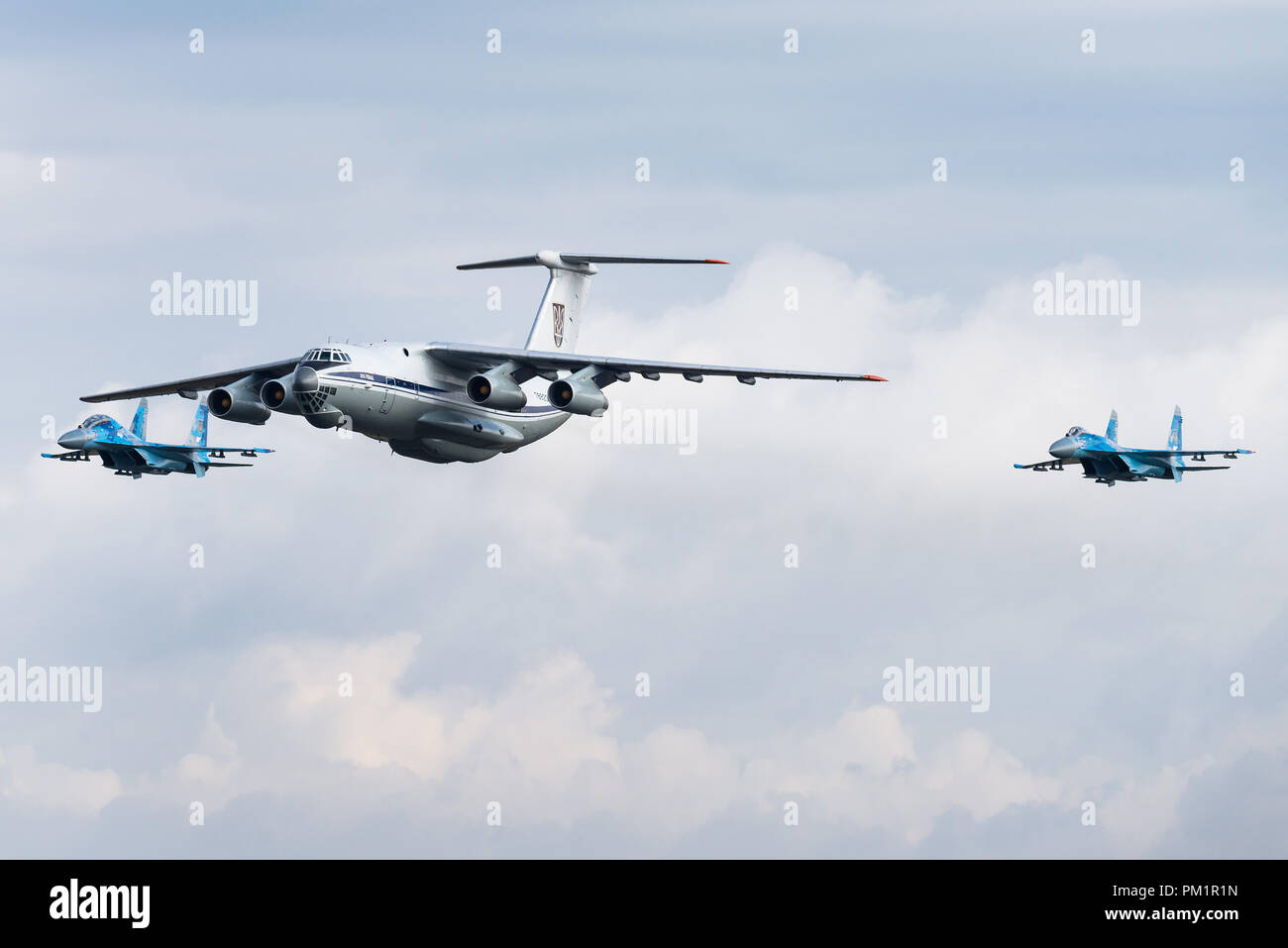 Un Iliouchine Il-76 avions de transport militaire de l'Armée de l'air ukrainienne est escorté par deux avions de chasse Sukhoi Su-27. Banque D'Images