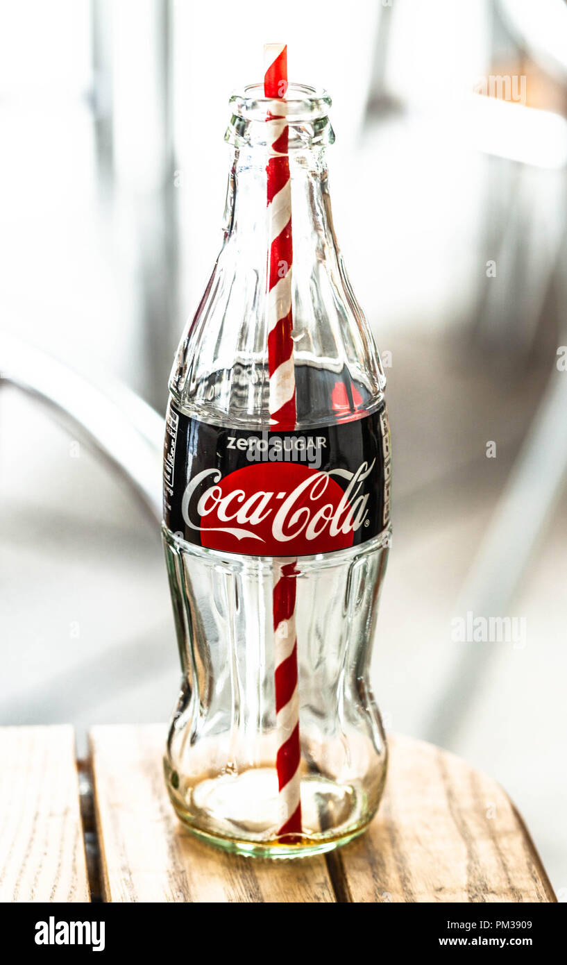 Un verre vide bouteille de CocaCola avec une paille à l'intérieur