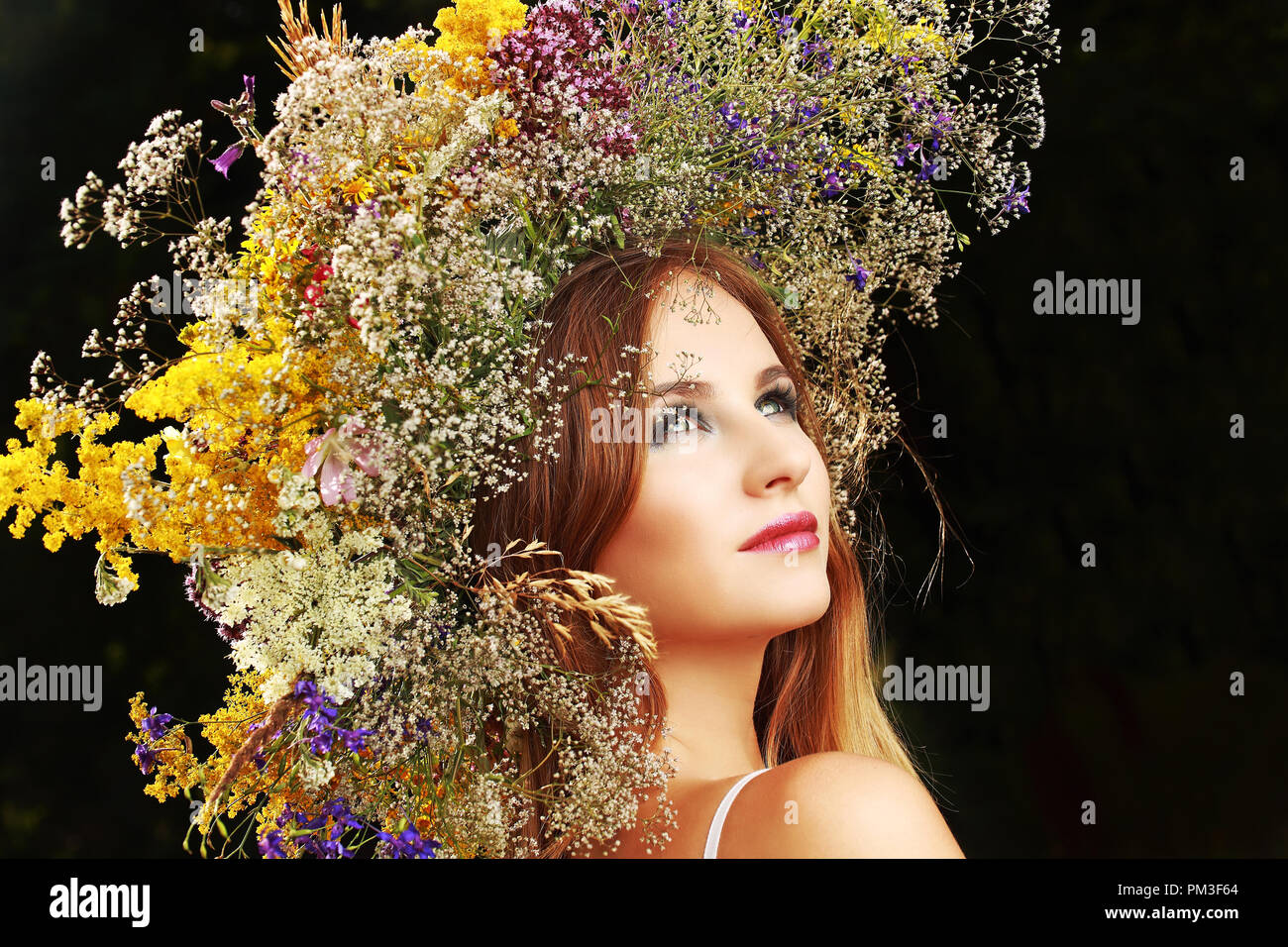 Une fille dans une guirlande de fleurs sur le terrain Banque D'Images