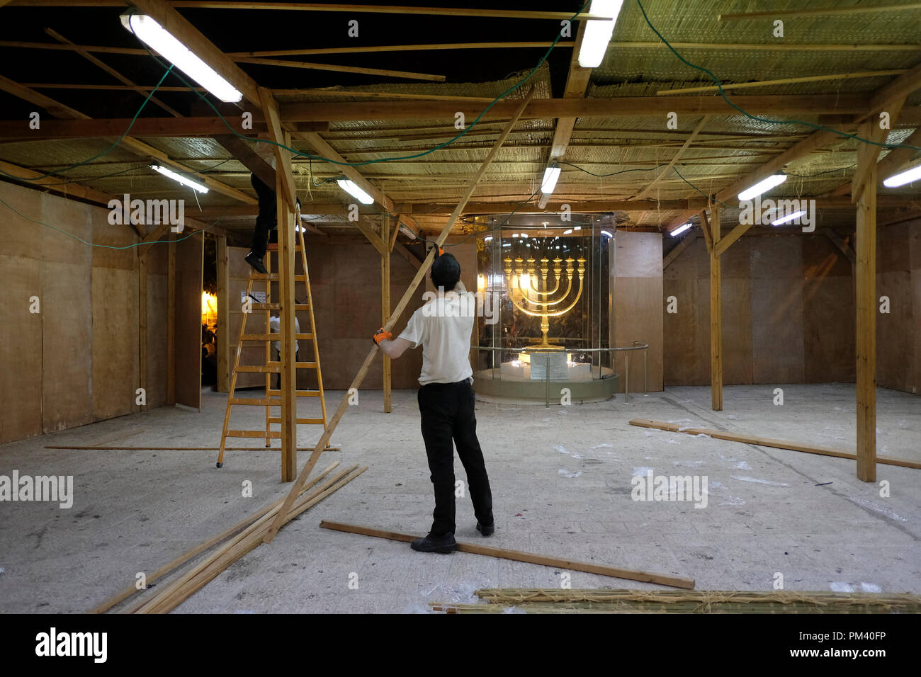 Les juifs religieux en bois Construction d'une Soucca ou cabane temporaire construit pour succah utiliser durant la semaine de fête de Souccot juif à la place Hurva dans lequel un énorme menorah d'or solide est placé dans le quartier juif de la vieille ville de Jérusalem-Est Israël Banque D'Images