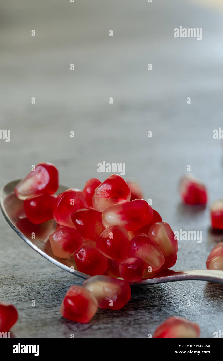 Graines de grenade sont en cuillère sur la table en bois. Close up,détail. Banque D'Images